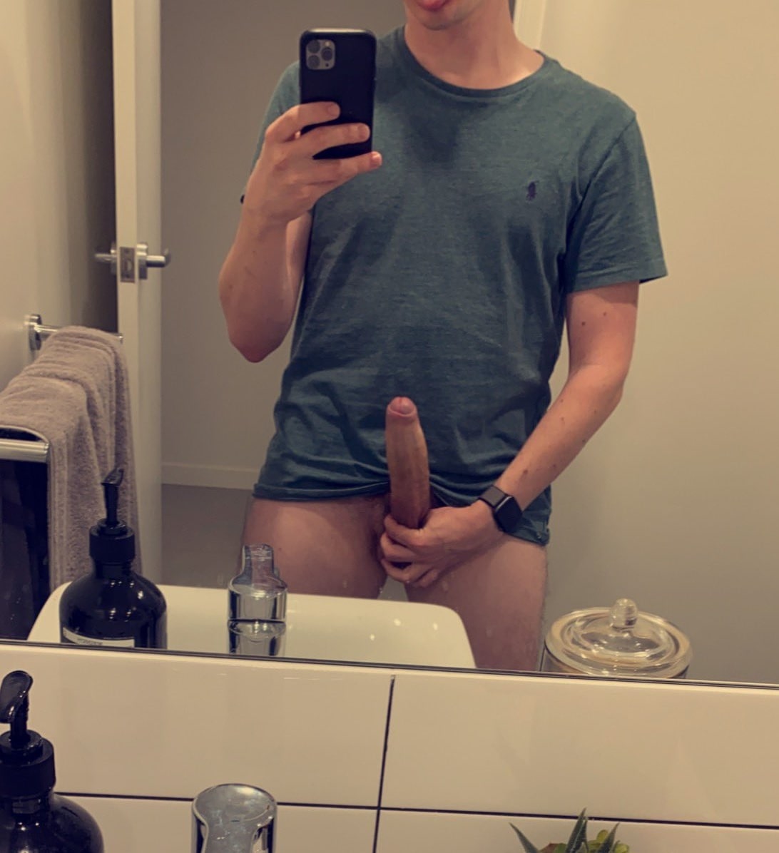 Horny boy in the bathroom taking a picture of his long hard uncut dick. 